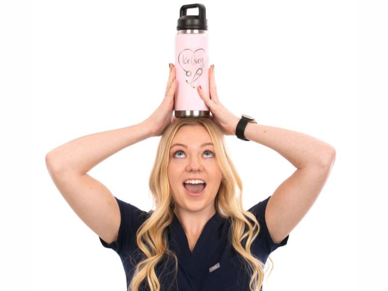 Young female posing with a water bottle on top of her head smiling