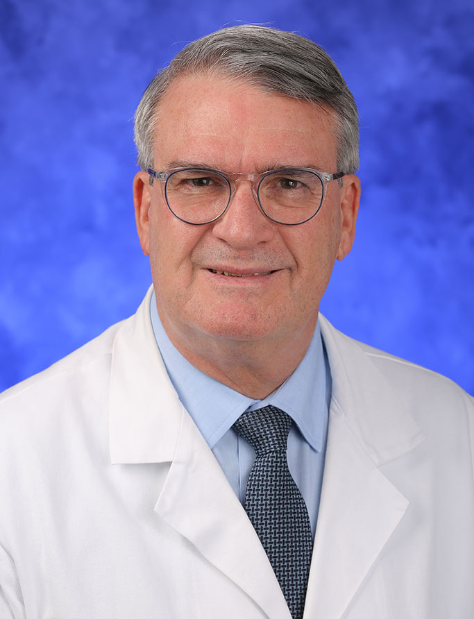 Donald Mackay, MD, is Interim Chair of the Department of Surgery at Penn State College of Medicine. He is pictured in a dress shirt, tie and medical coat against a professional photo background.