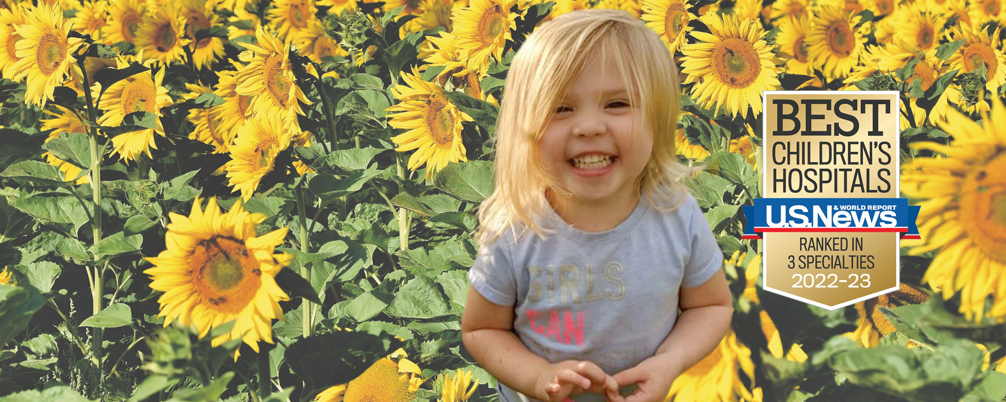 Young child smiling in a field of sunflowers