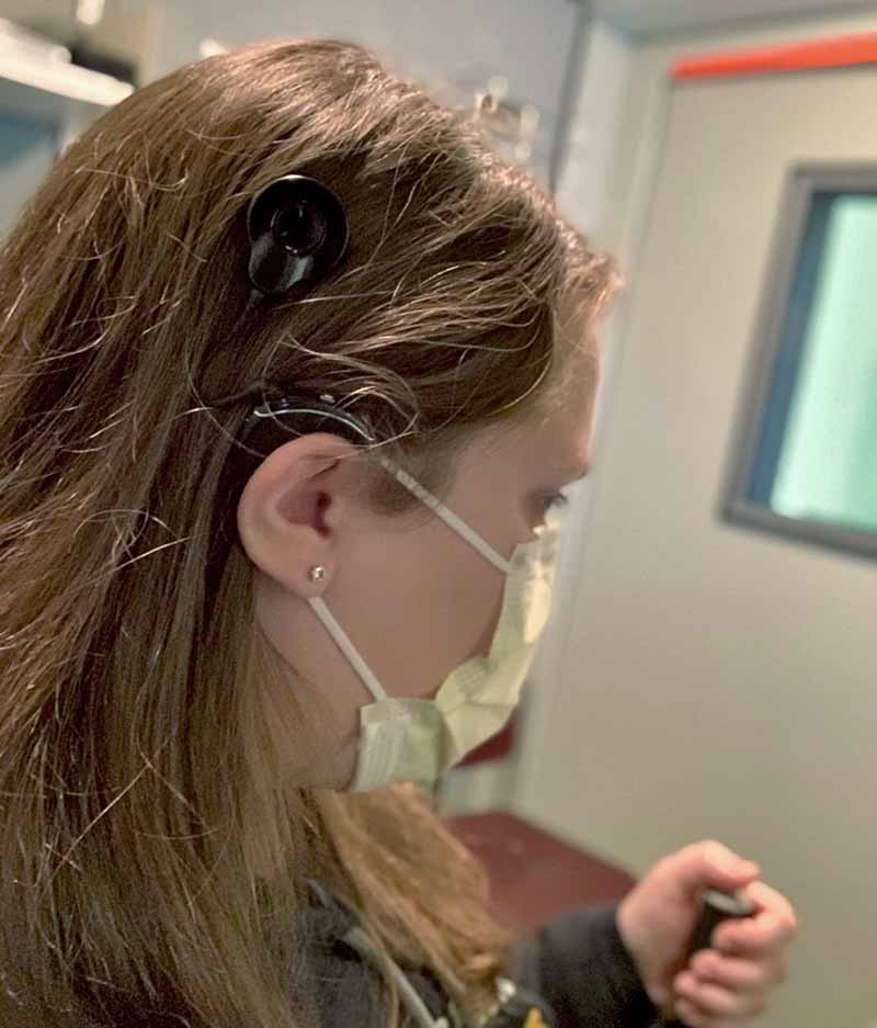 An audiology patient, wearing a cochlear implant is taking an aided hearing test.