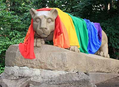 The Nittany Lion statue is shown draped in rainbow colors in support of LGBTQ+ communities.
