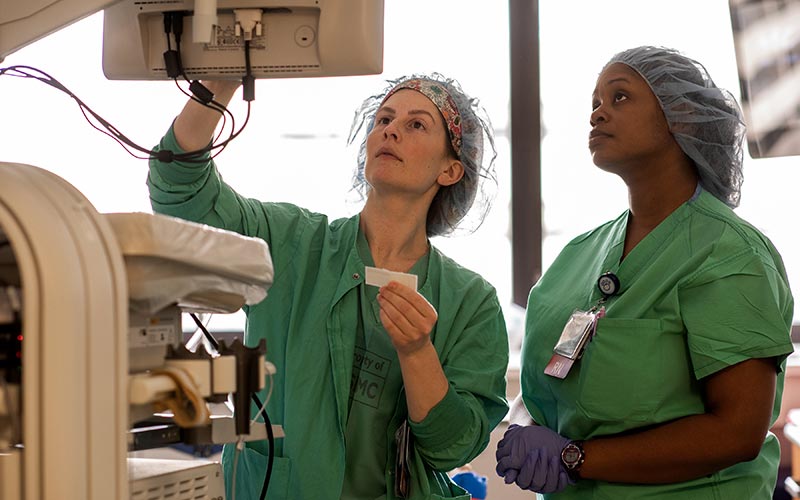 Two operating room registered nurses are pictured reviewing a patient’s monitor.