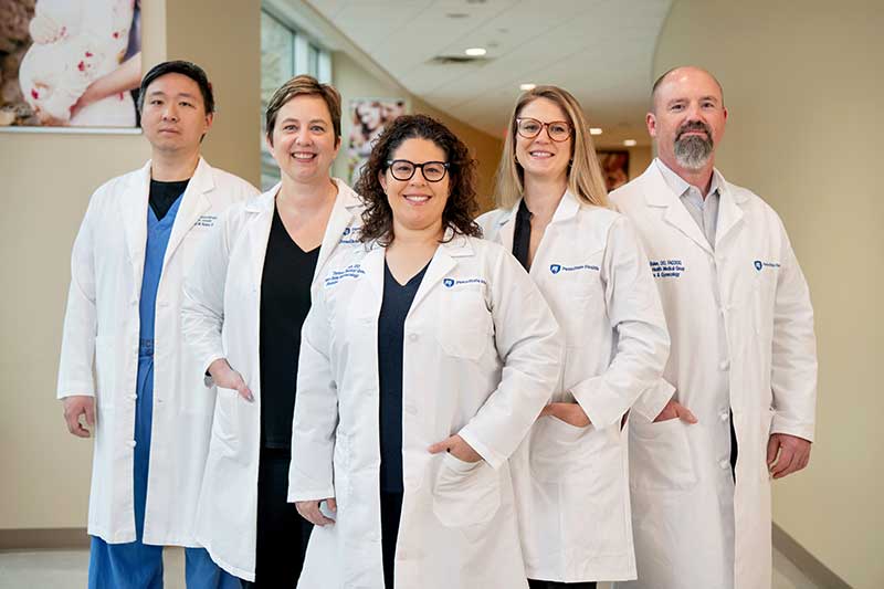 5 gynecologic surgeons are grouped in the hallway at St. Joseph Medical Center.