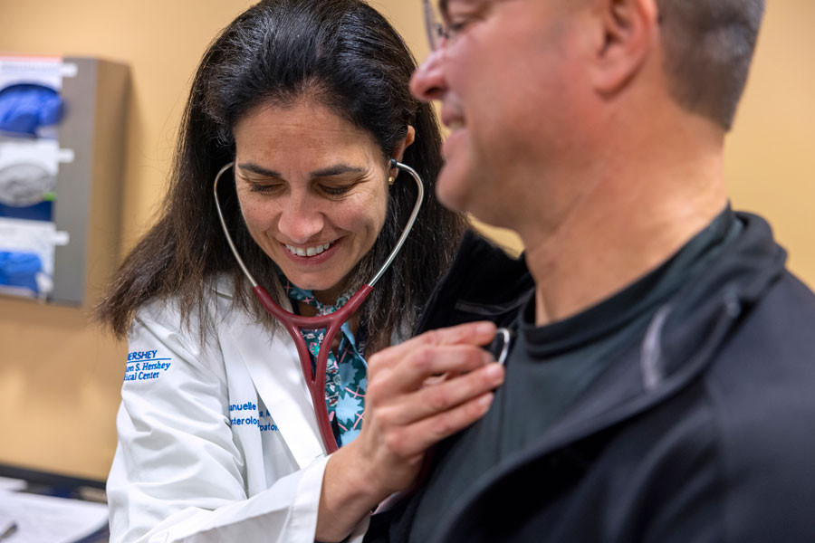 Female doctor listening to a patients heart.