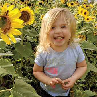 Young girl smiling in a field of sunflowers