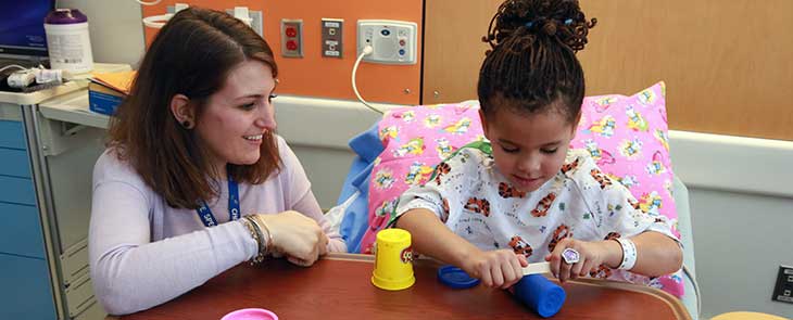 A child life staff member works with a child at Penn State Children's Hospital