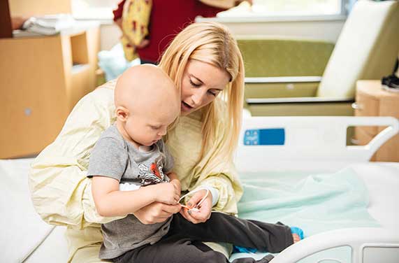 A caregiver works with a baby