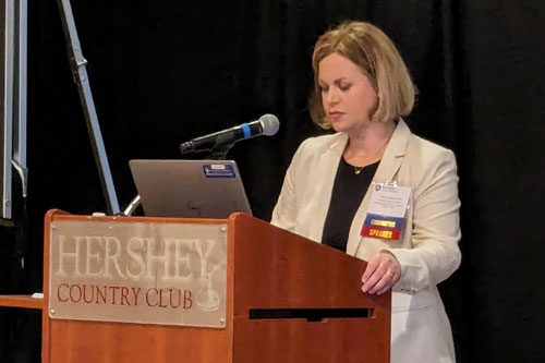 Female at podium presenting at a conference.