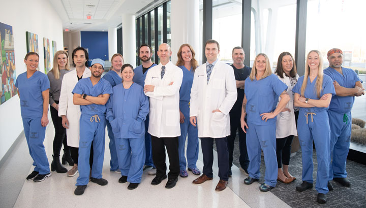 Team of medical professionals standing inside a hallway.