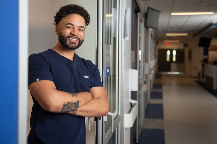 Lance Whitehead, a registered nurse at Penn State Health, stands smiling with his arms crossed.