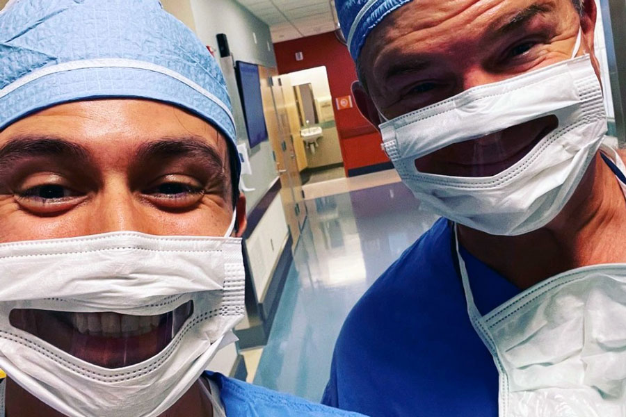 Two male doctors wearing special face masks that allow for lip-reading in those that are hearing impaired.