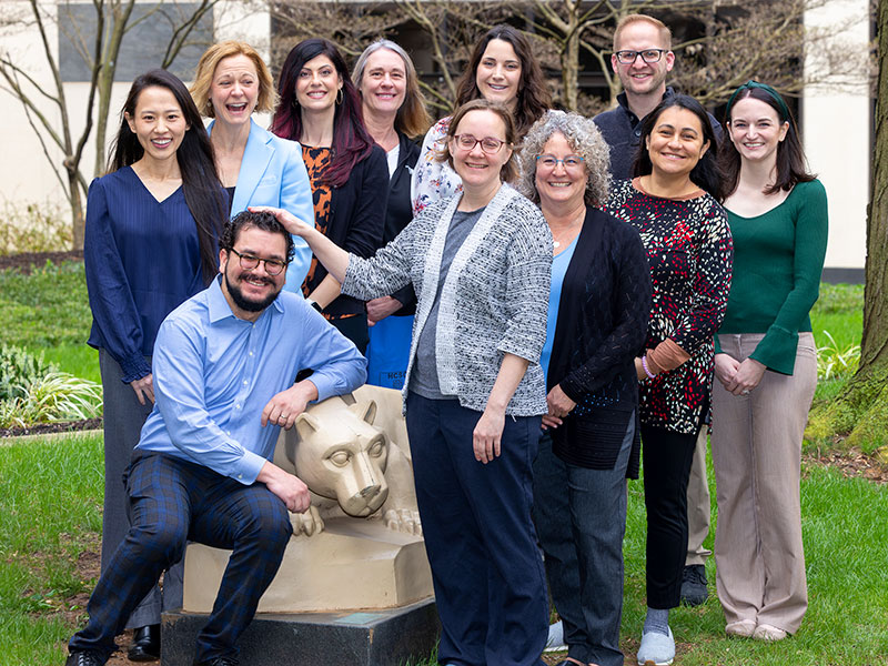 The palliative medicine care team pose around the Penn State Nittany Lion statue