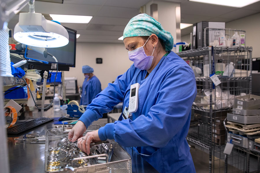 Sabrina Sechrist, a sterile processing department manager at Penn State Health Milton S. Hershey Medical Center, wearing blue surgical scrubs, preps instruments for surgery.