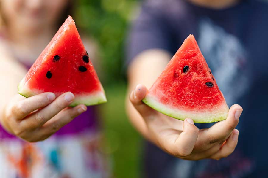 People holding watermelon slices