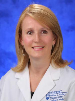 A professional head and shoulders photo of Dr. Sarah Iriana. She is wearing a white medical jacket.