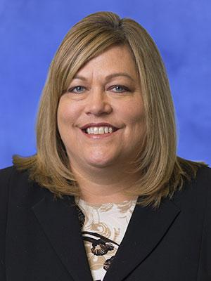 Kim Feeman, President, Pennsylvania Psychiatric Institute, is shown in a professional headshot. She has shoulder-length hair and is wearing a suit and patterned blouse.