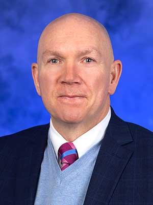 Dennis Sutterfield, in a professional head and shoulders photograph.