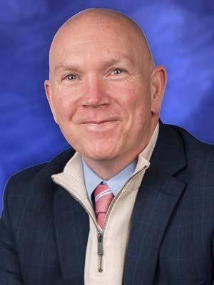 Dennis Sutterfield, in a professional head and shoulders photograph.