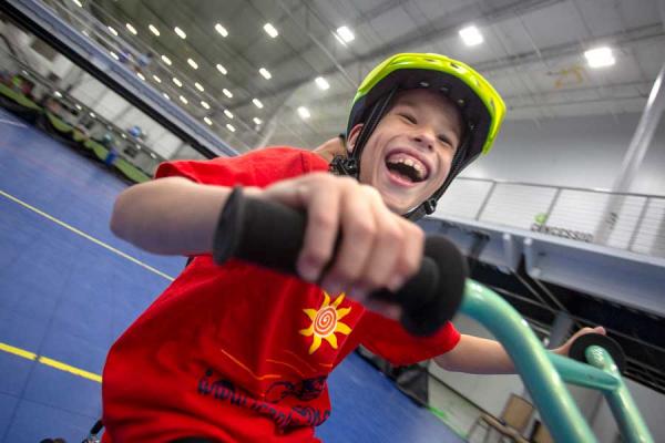 Young CMN child riding his bike indoors