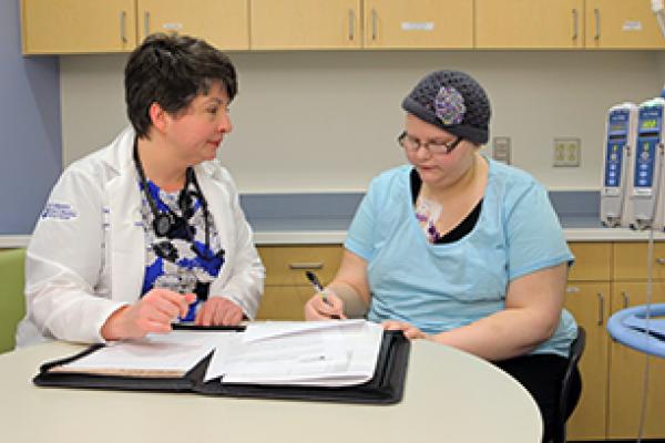 A Penn State researcher helps a clinical trial patient.