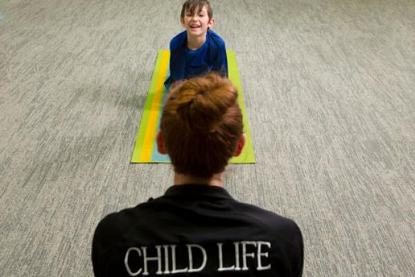 Young child performing yoga in front of a yoga instructor