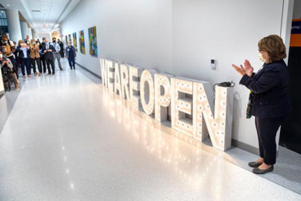 Barb Zuppa, chief nursing officer at Lancaster Medical Center stands next to a light-up we are open sign