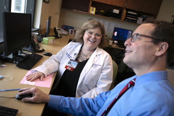 Aileen McCormick, an RN at Penn State Health Milton S. Hershey Medical Center, and a male colleague meet to review a project.