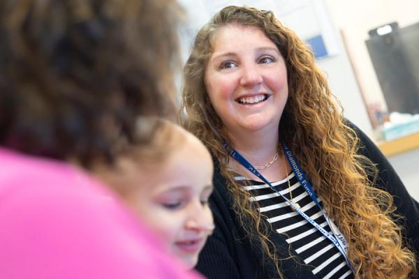 Young mother sitting with her child speaking to another female.