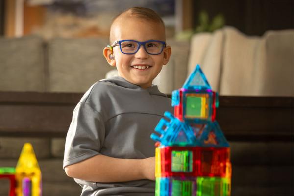 Young child sitting on the ground playing with a logo set.