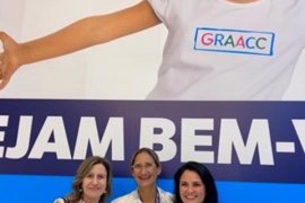Three doctors stand together at a hospital