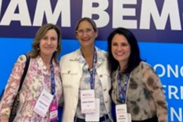 Three doctors stand together at a hospital