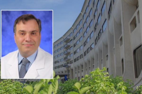 A head and shoulders professional portrait of Dr. Dino Ravnic against a background image of Penn State College of Medicine.
