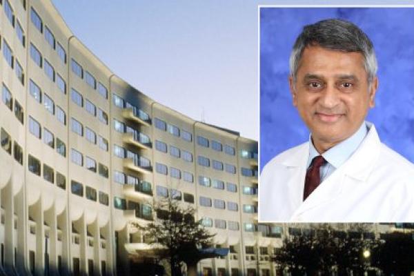A head and shoulders professional portrait of Dr. Yatin Vyas against a background image of Penn State College of Medicine.