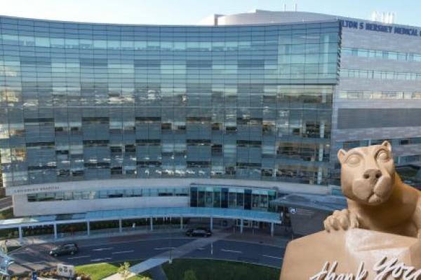 A statue of the Penn State Nittany Lion with the words "thank you" placed in front of it, is superimposed over an exterior image of Penn State Health Children's Hospital.