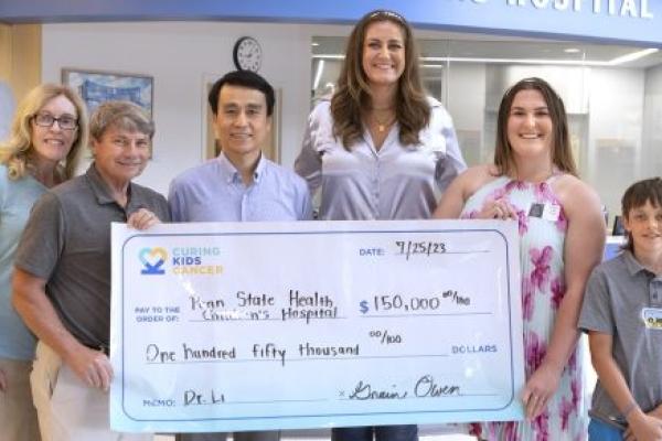Six people stand behind a presentation check made out to Penn State Health Children's Hospital for $150,000.