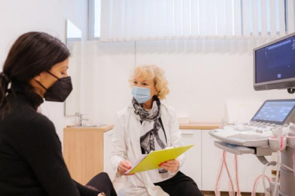 Doctor and patient with protective face masks during the medical examination
