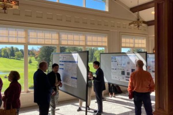Individuals gather around research posters during the Inflammatory Bowel Disease Research Symposium on Friday, Oct. 13 at Hershey Country Club.