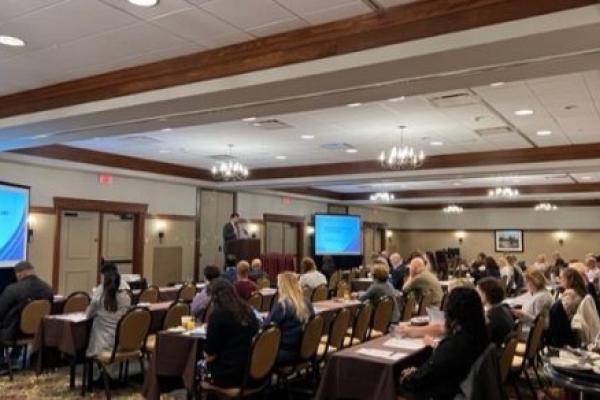 Several rows of people are seated in a conference room, listening to a speaker, at the Inflammatory Bowel Disease Research Symposium on Oct. 14 at the Hershey Lodge.