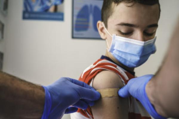 A child receives a bandage after receiving a shot.