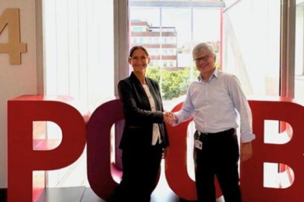 Two people standing next to each other and shaking hands.