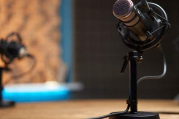 A podcast microphone on a desk in a recording studio