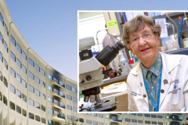 A portrait of Dr. Elaine Eyster in a laboratory by a microscope. The photo is placed against a background image of Penn State College of Medicine.