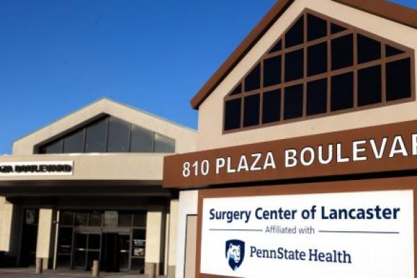 An external photo of Surgery Center of Lancaster, with a sign prominent in the foreground.
