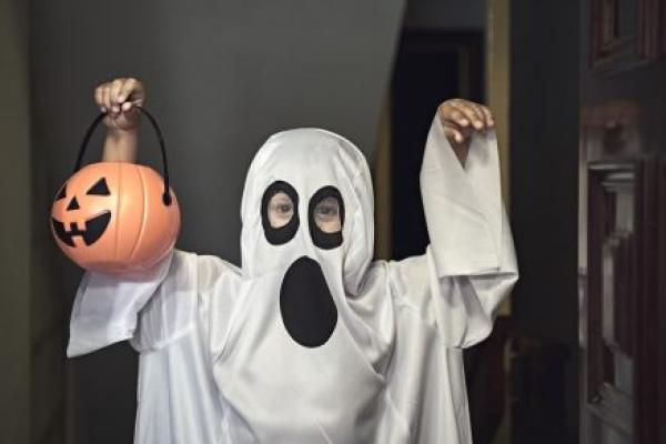 A little boy dressed as a ghost.