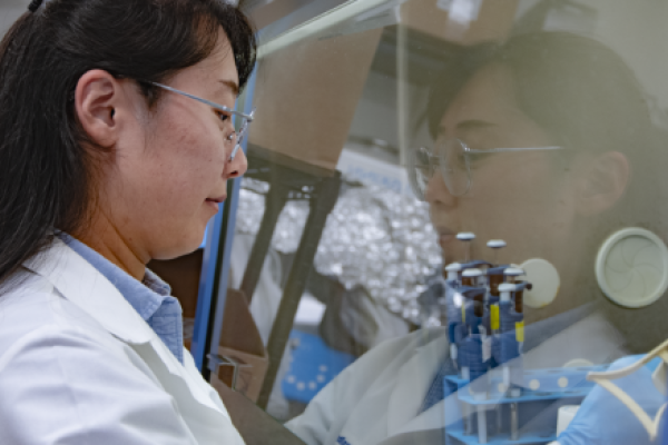 Person in lab coat performs experiment in lab