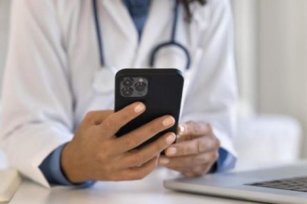 A close-up of a doctor holding a smartphone.
