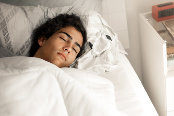 Teenager asleep in bed