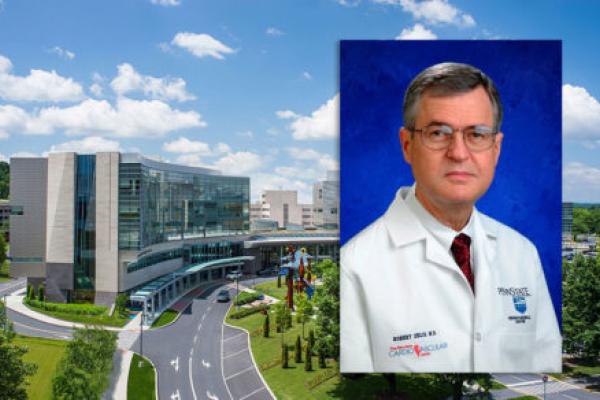 A head-and-shoulders professional photo of Dr. Robert Zelis is superimposed on an aerial view of the campus of Penn State Health Milton S. Hershey Medical Center in Hershey, Pa.