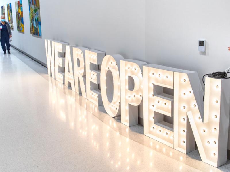 Barb Zuppa, chief nursing officer at Lancaster Medical Center stands next to a light-up we are open sign