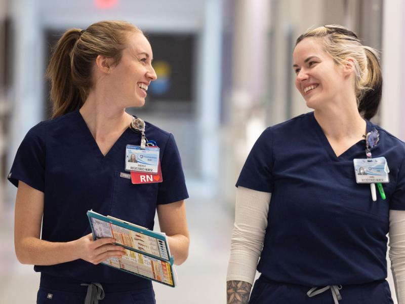 Two registered nurses at Penn State Health Lancaster Medical Center talking in the hallway.